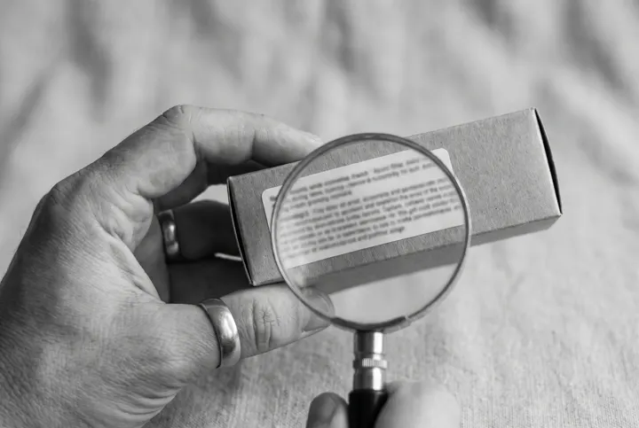 Magnifying glass over the ingredient list of a serum box
